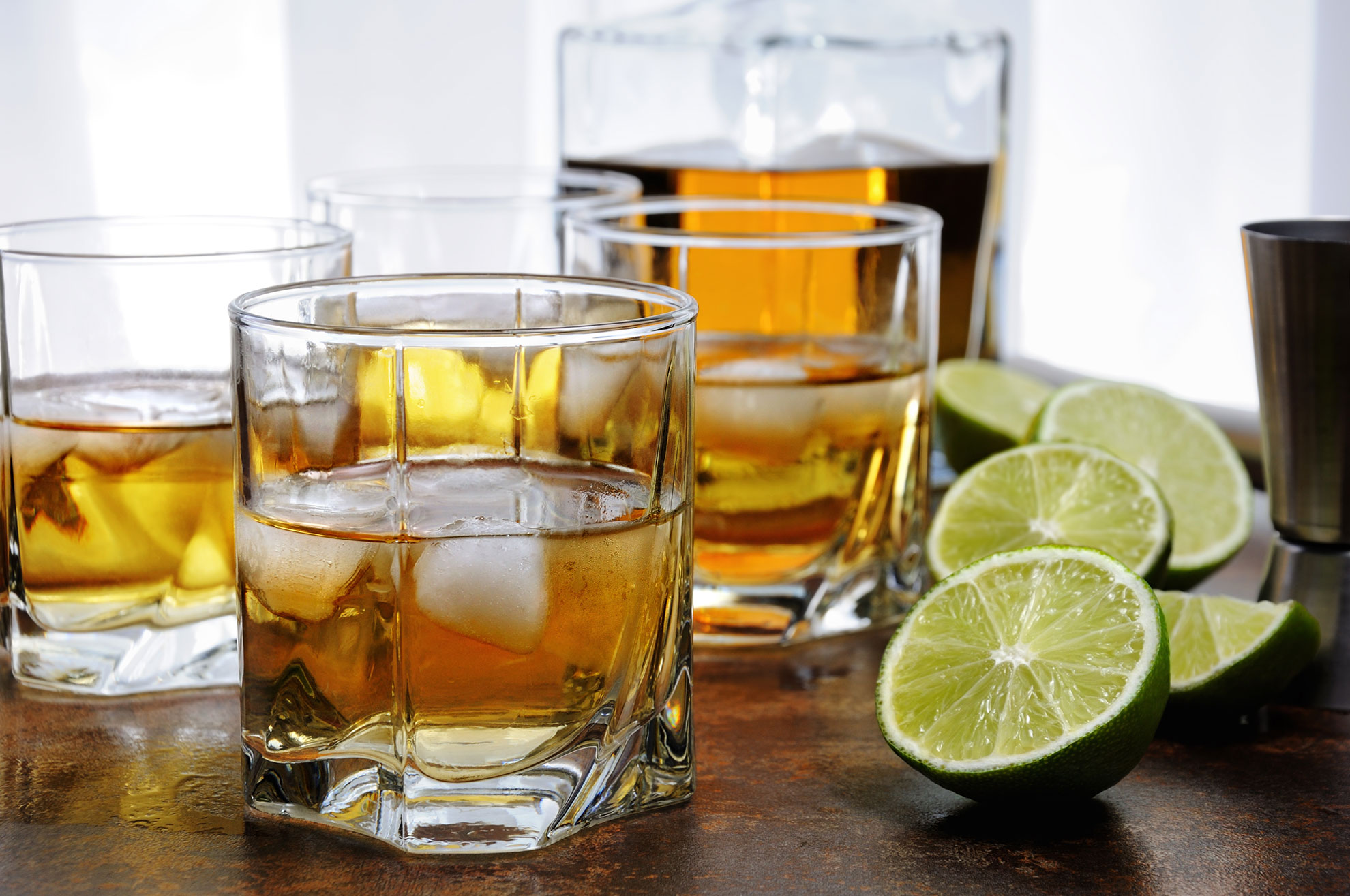 Alkoholische Getränke – hier Gläser mit Drinks aus Spirituosen, Eiswürfel und Limetten auf einem Tisch – sind in Österreich und in der EU klar definiert.