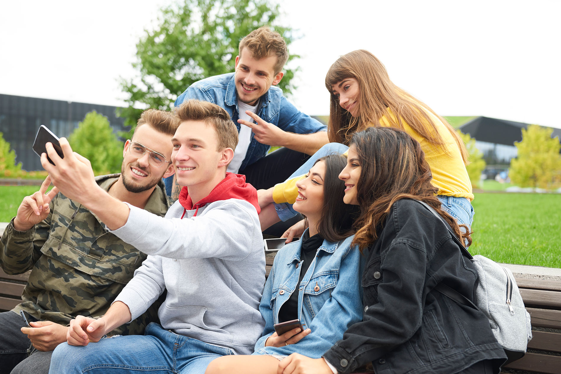 Eine Gruppe junger Menschen macht Selfies: Jugendliche sind vor übermäßigem Alkoholkonsum zu schützen.