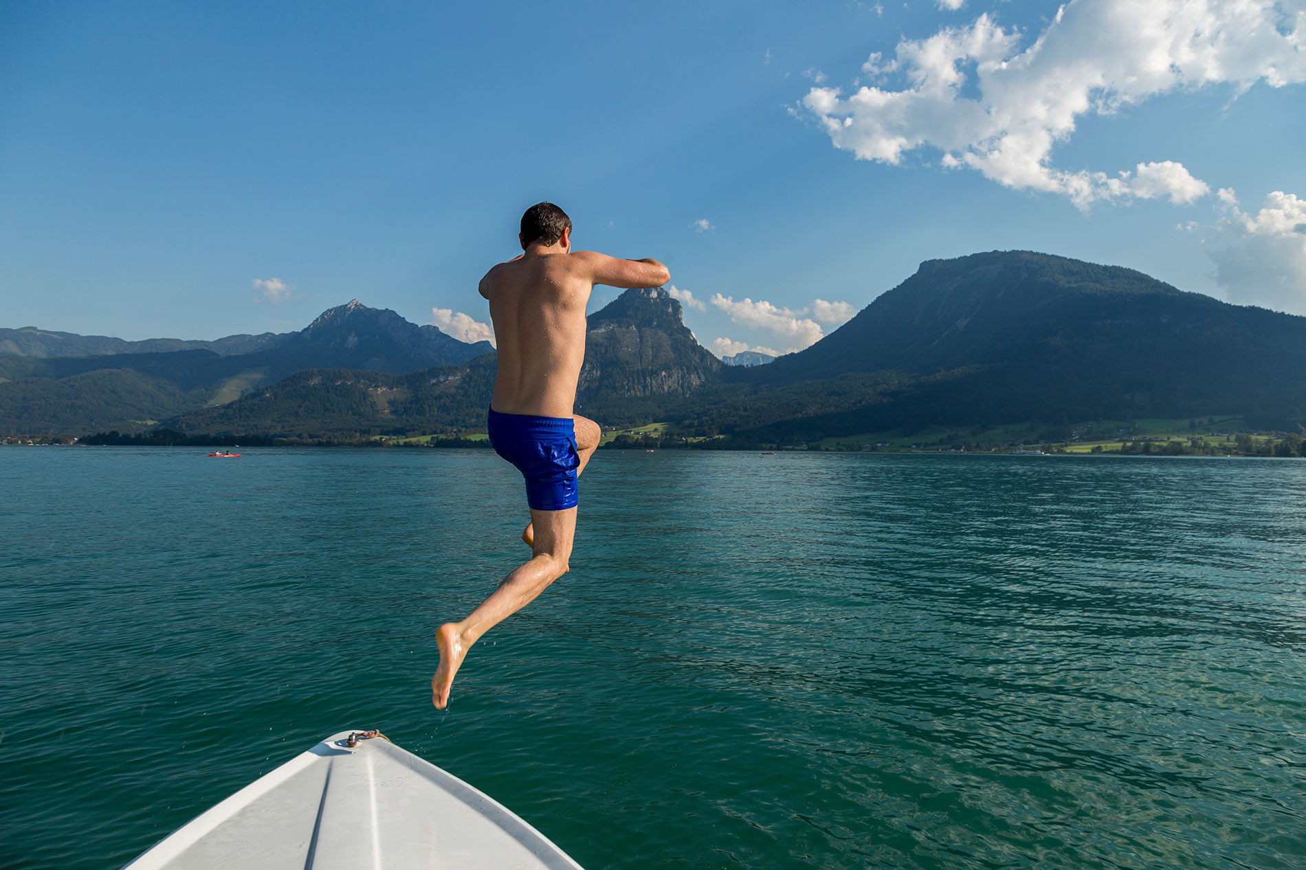Eine junger Mann springt vom Boot in den See: Bei praller Sonne ist Alkoholkonsum zu vermeiden.
