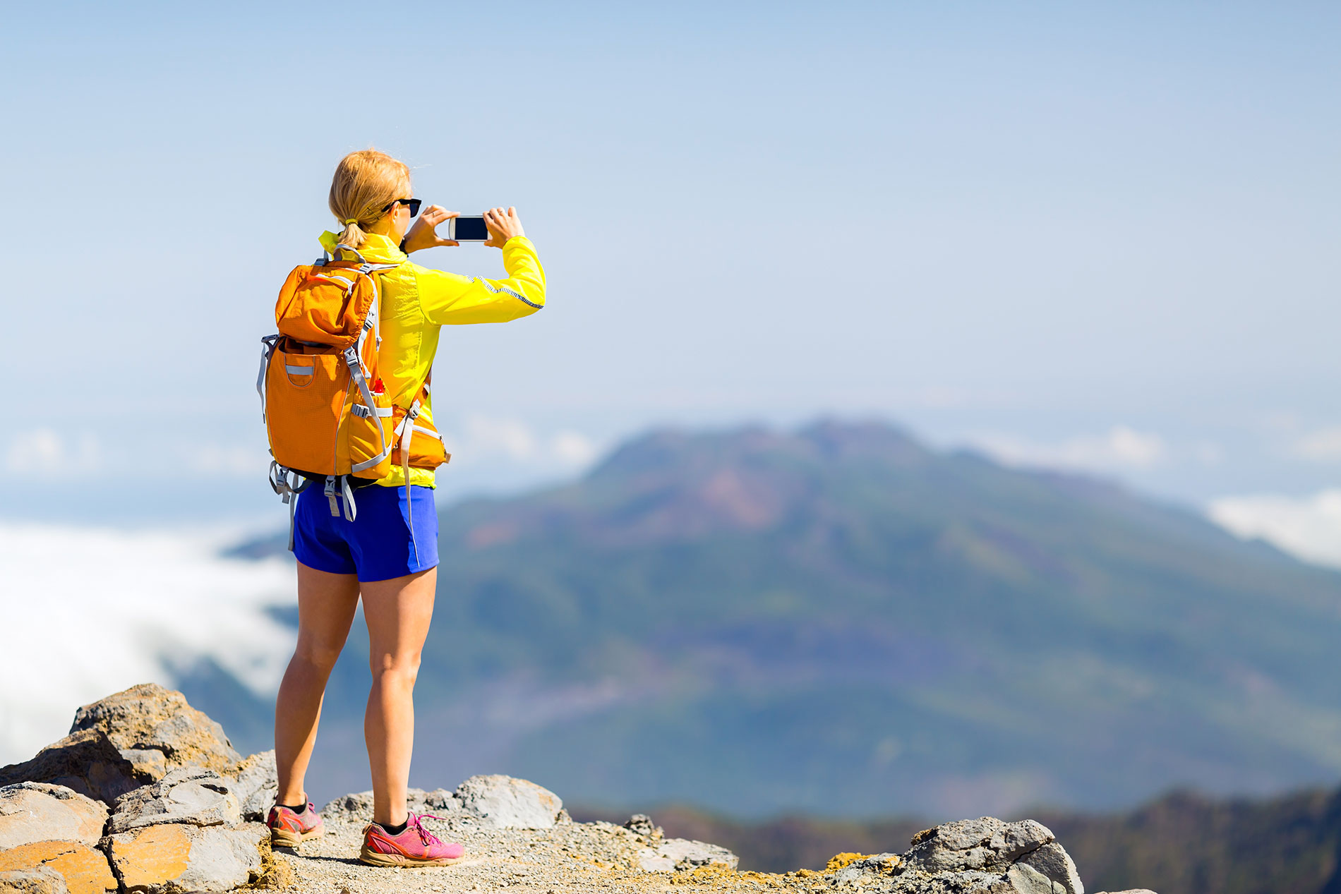 Frau bei einer Wanderpause in den Bergen: Bei sportlichen Aktivitäten ist der Verzicht auf Alkohol empfehlenswert.